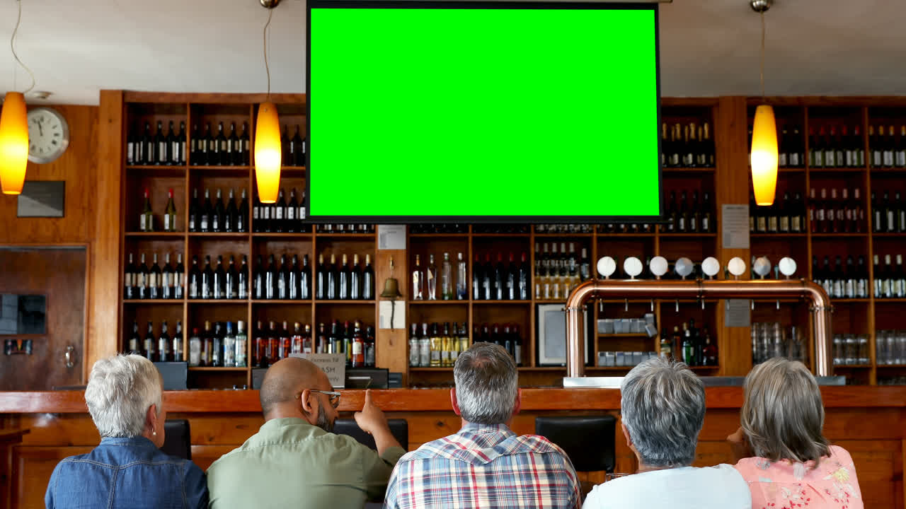 행복 한 친구 들 이 바 4k 에서 텔레비전 을 보고 있다