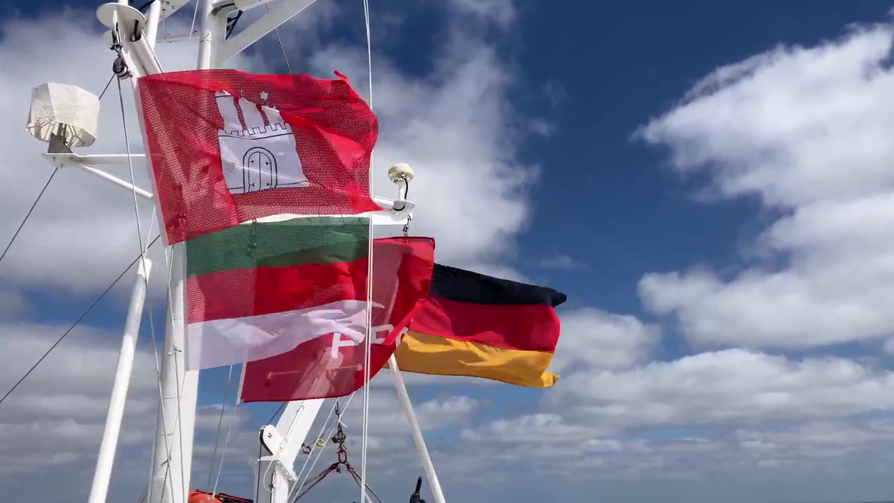 Bandiere colorate del traghetto che sventolano sopra il ponte passeggeri durante la traversata in mare vicino a Helgoland, viste dalla prospettiva di bordo