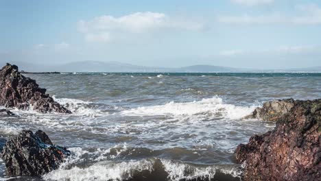 Time-lapse-of-waves-hitting-rocks-on-coast-and-rolling-clouds