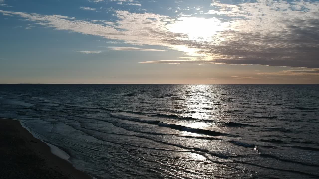 Splendida vista del mare calmo e del sole basso dietro le nuvole