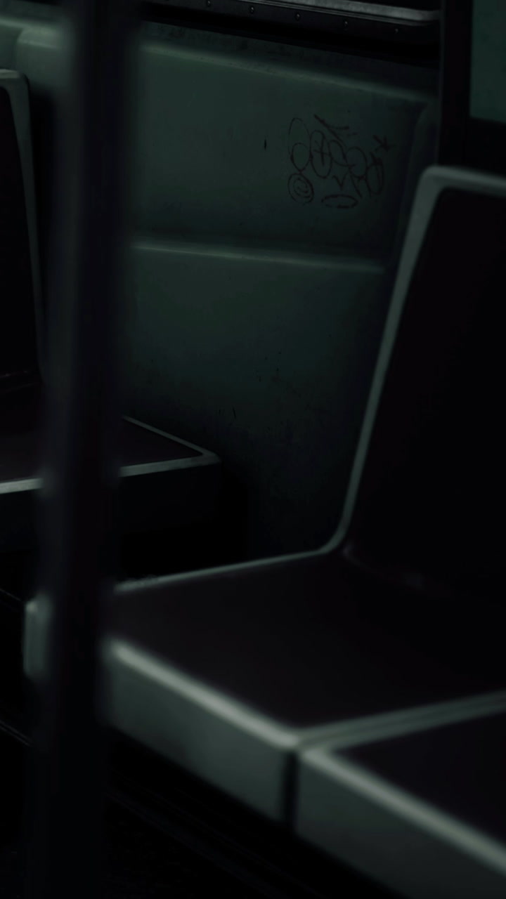 Seats in a bus interior at night with low lighting and empty space