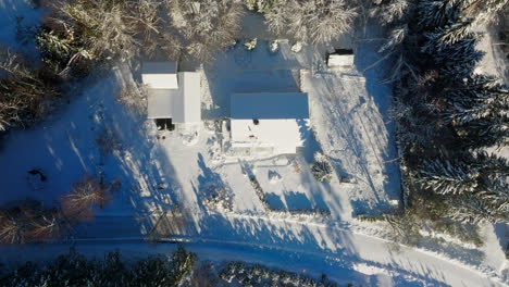 aerial screwdriver shot above partly cleaned photovoltaic system on a snowy house