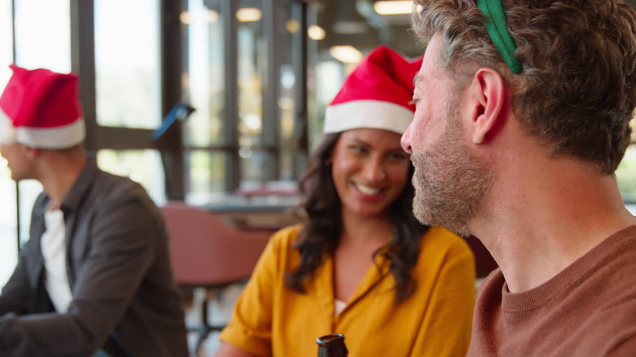 el personal celebrando en la fiesta de navidad disfrazándose disfrutando de bebidas en la oficina