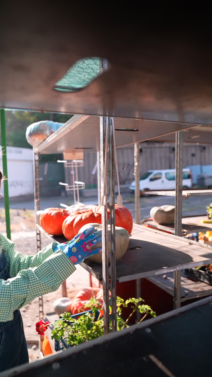 mujer en un mercado de agricultores mirando calabazas