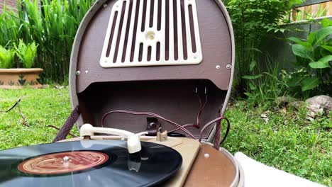 Eine-Alte-Schallplatte-Dreht-Sich-Auf-Einem-Alten-Retro-Plattenspieler-Aus-Den-1950er-Und-1960er-Jahren-Und-Spielt-Draußen-Im-Garten-Musik