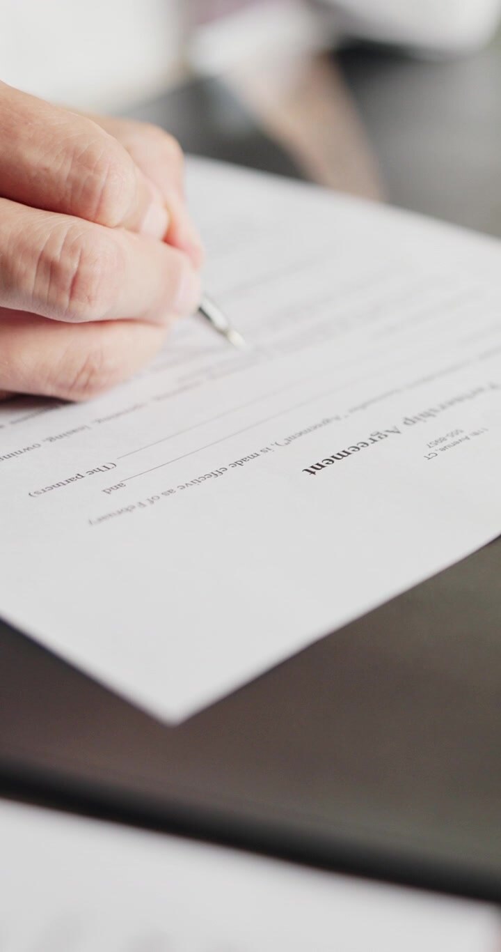 Person Signing a Partnership Agreement Document