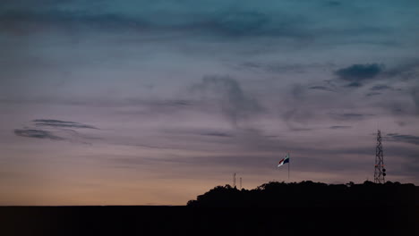 Panama-flag-waving-on-top-of-the-Ancon-Hill-in-Panama-City,-twilight-slow-motion