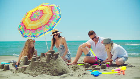 family building sandcastles on the beach