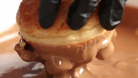 caramel donut being decorated dipped in caramel