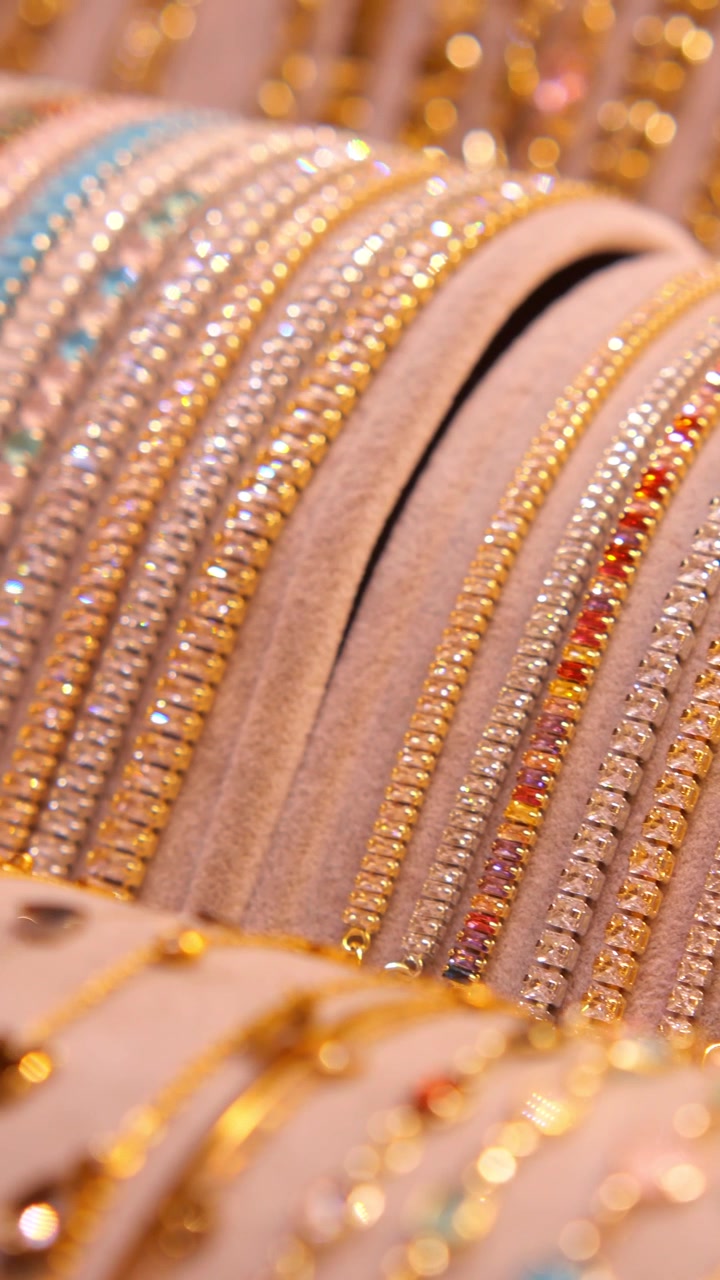 Rangées de bracelets étincelants en or et argent ornés de pierres précieuses colorées.