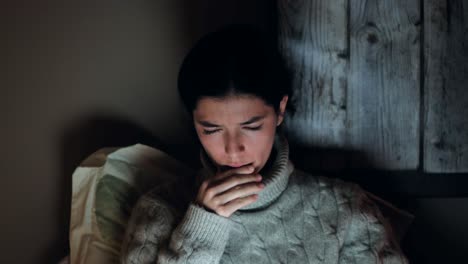 Thoughtful-Woman-Pondering-Over-News-on-Laptop-in-Dim-Room