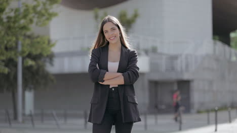 Girl-standing-with-crossed-arms-and-smiling-at-camera