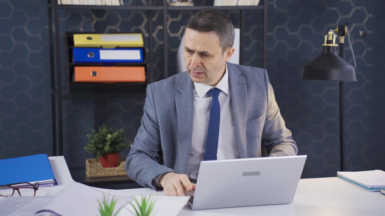 Uomo che lavora in un ufficio commerciale dove, stressato e con tempi stretti, lavora velocemente ed è impegnato.