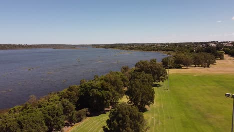 Imágenes-Aéreas-Sobre-Un-Parque-Recreativo-Verde-Y-El-Lago-Vecino