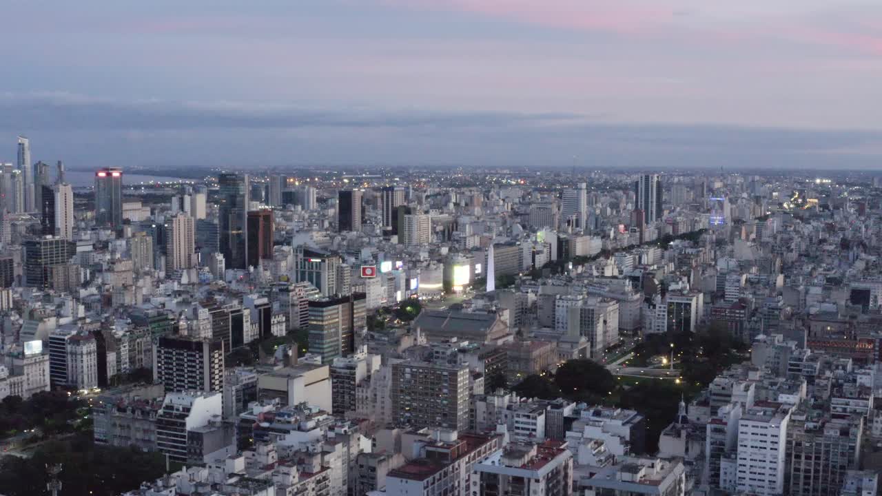 Drone aerial 4K footage of the huge city of Buenos Aires, Centro Porteño in a pink sunset, Argentina. View of Argentine buildings and skyscrapers and the famous obelisk from above. City life concept.