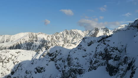 snow covered mountain landscape with dramatic ridges and clear sky above, exploring the scenic valleys