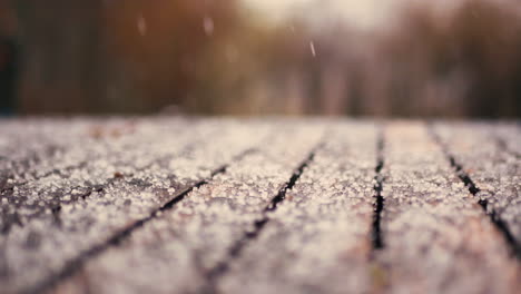 Close-up-of-snow-falling-on-a-table-outside