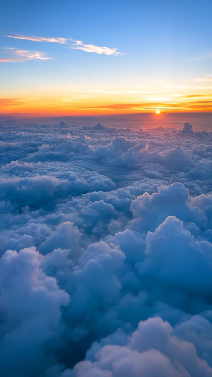 Sequenza aerea dell'alba sopra nuvole cumuliformi ondeggianti, che mostra luce e movimento in evoluzione.