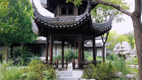 a serene traditional chinese garden in tianjin, featuring lush greenery, intricate architecture, and a tranquil pond, showcasing the beauty of classical chinese design.