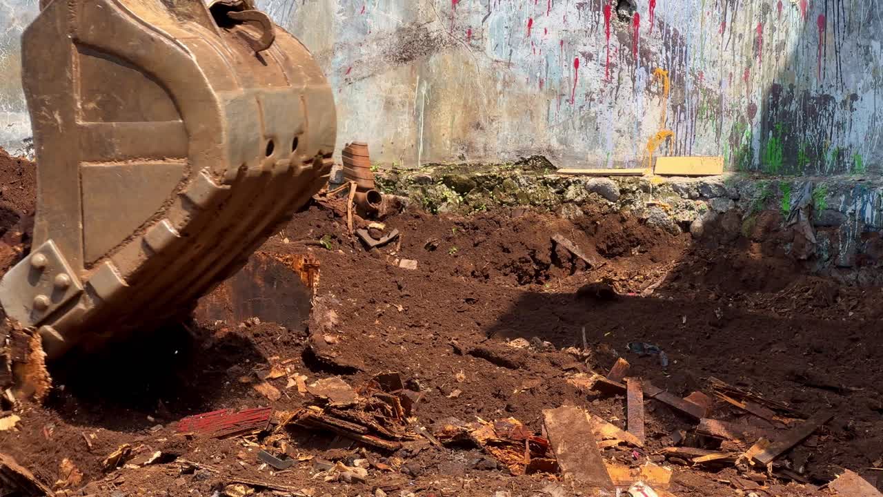 Close-up footage of an excavator bucket digging soil during construction work
