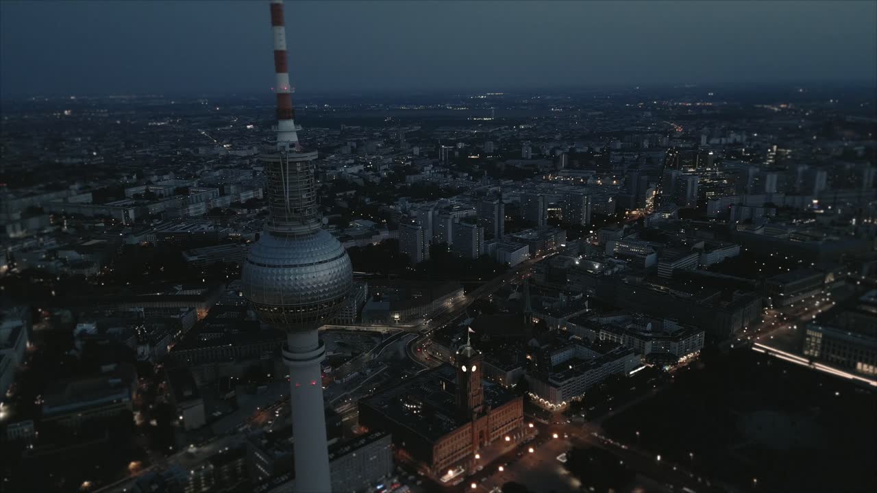 Bredt luftfoto af Berliner Fjernsynstårn og rådhus i skumringen.