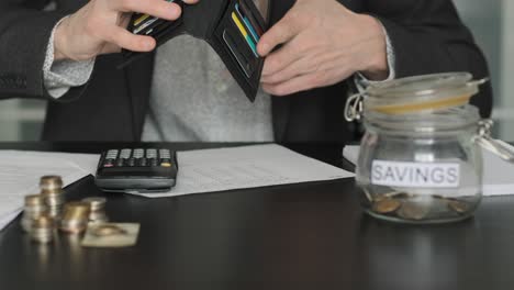 business man pouring money from wallet on desk