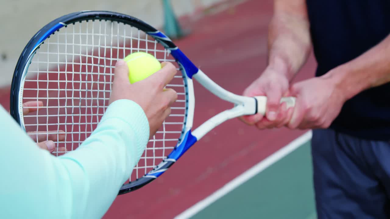 Trener hjelper mann med å spille tennis