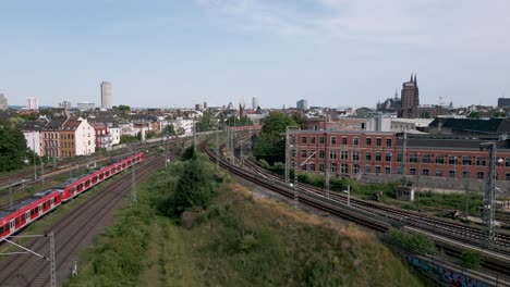 Two-commuter-S-Bahn-trains-meet-in-the-north-of-cologne-just-before-the-central-station-in-a-midday-of-June-2022