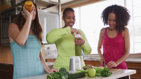 diverse happy female friends trying healthy drinks at home