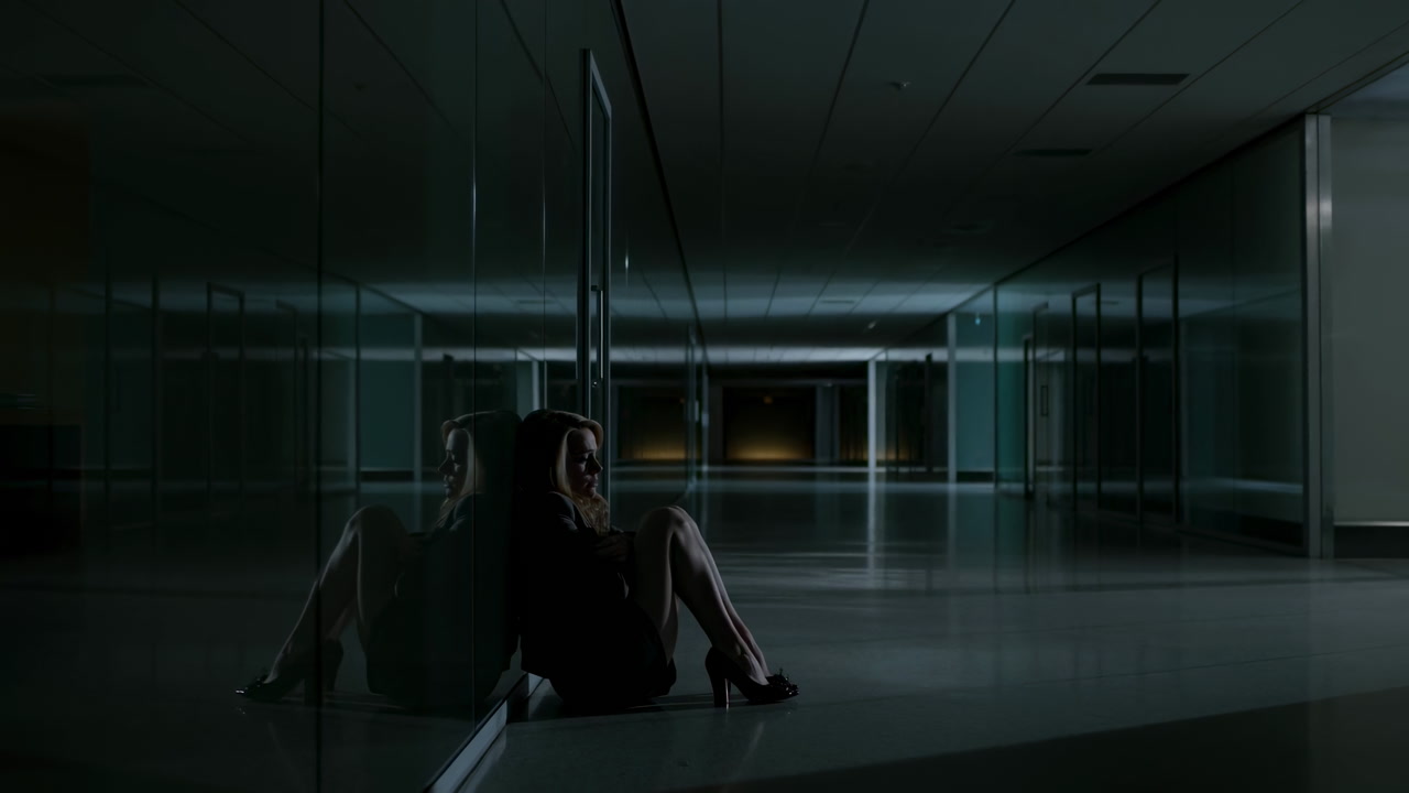 Lonely Woman Sitting Against Glass Corridor At Night, Reflection On Polished Floor, Modern Corporate Lobby,
