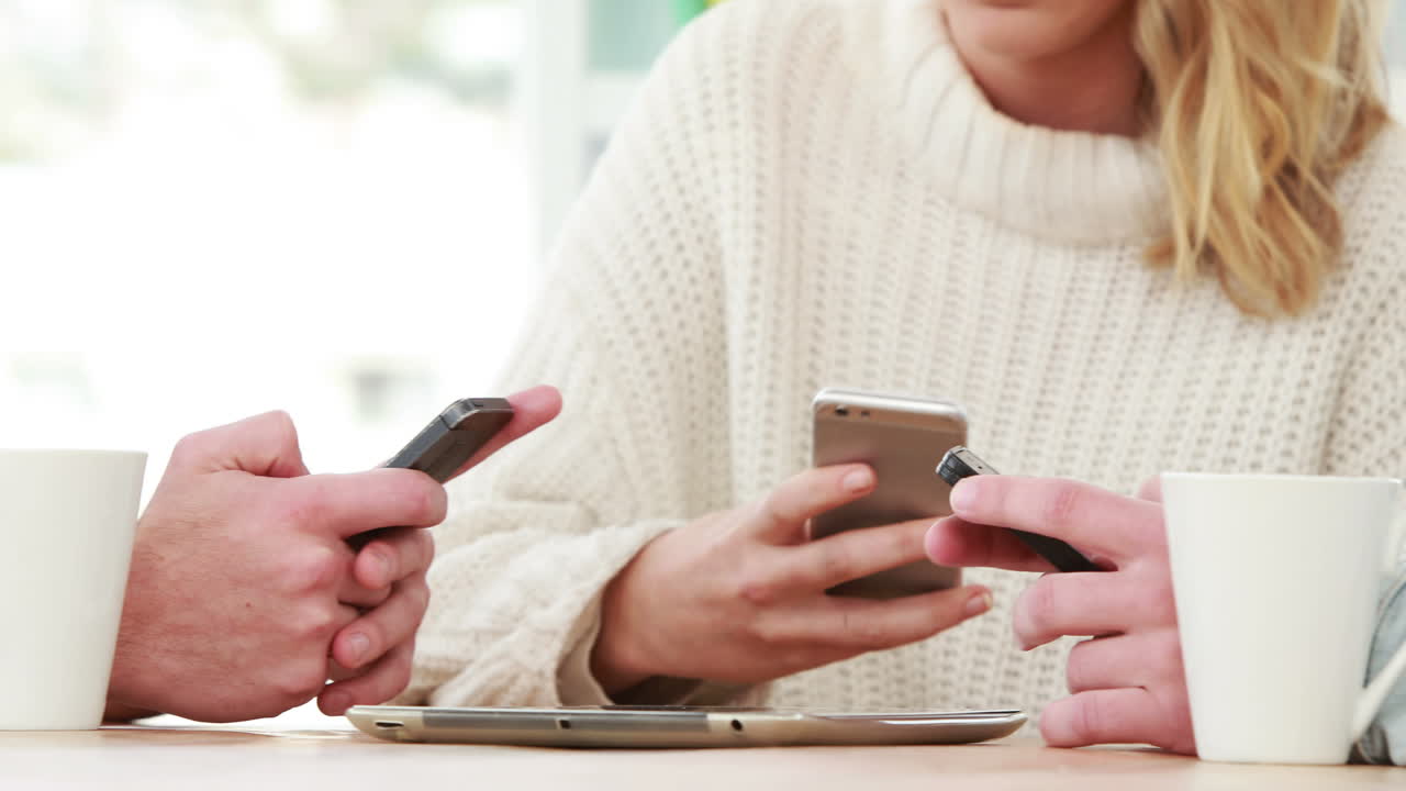 hipsters usando sus teléfonos inteligentes juntos