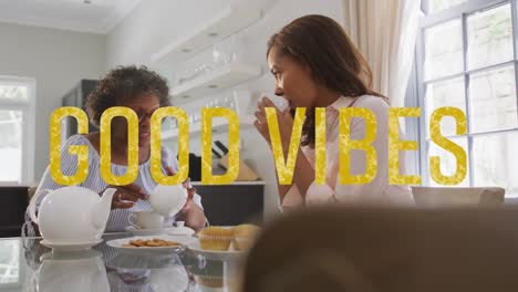 animation of good vibes text over two women talking and having tea at home