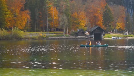 people canoeing on the lake bohinj on a autumn day in slovenia