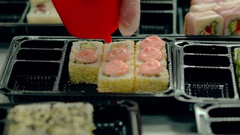 cook decorates with cream fried japanese rolls with sesame