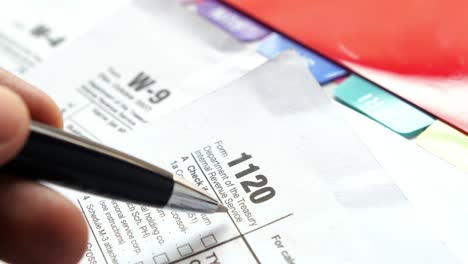 many us tax form on table , w-9, w-4, 1120 form