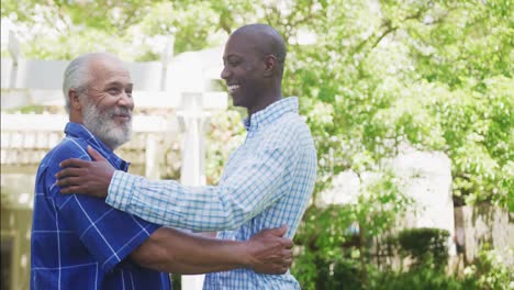 padre afroamericano y hijo adulto abrazándose