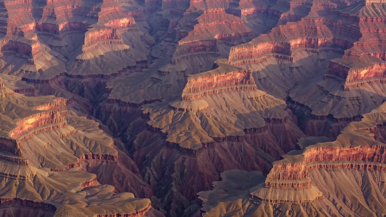 Aerial view of the Grand Canyon's rugged landscape, showcasing layered rock formations and deep