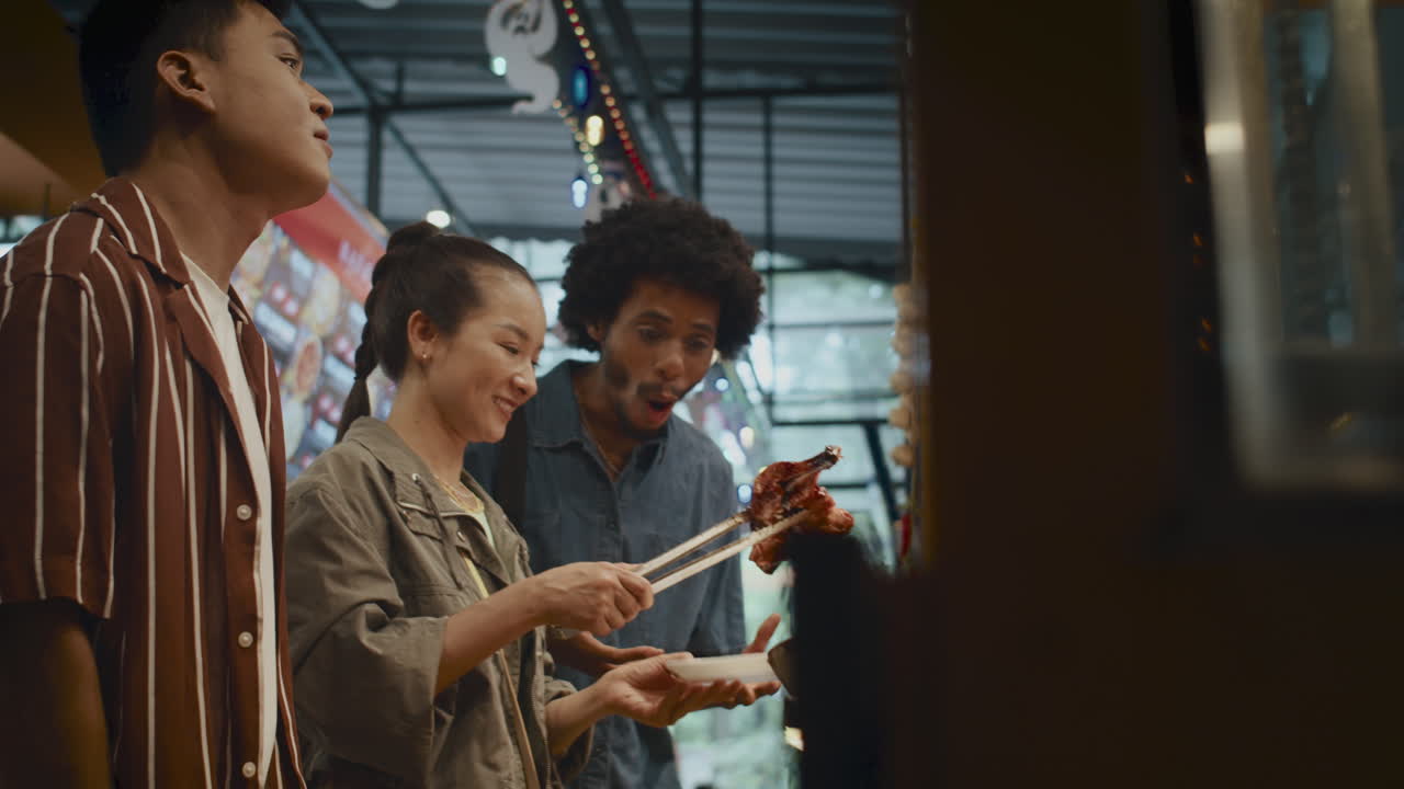 Friends Buying Fried Chicken at Street Food Market