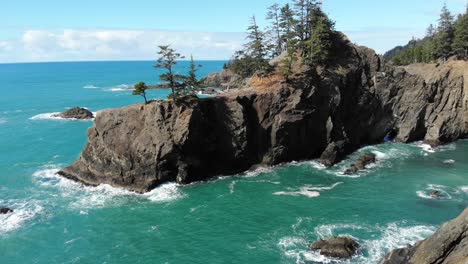 drone flies over sea stacks in ocean