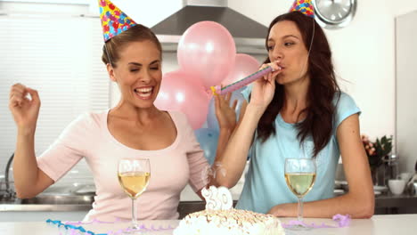 woman blowing candle while celebrating her birthday with a friend