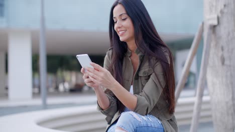 joven feliz disfrutando de un sms en su móvil