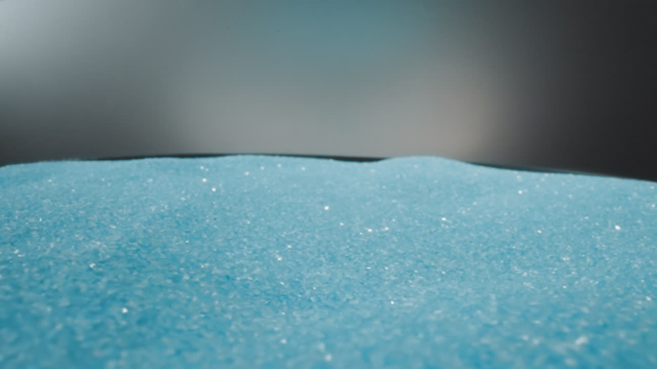 arena azul brillante estremecida por las sacudidas en un fondo gris