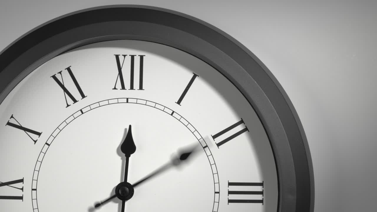 Quadrante di orologio con numeri romani in time lapse su parete bianca.