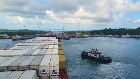 a powerful tugboat maneuvers a massive container ship loaded with cargo through the locks and waterways of the famous panama canal, a vital hub for international trade