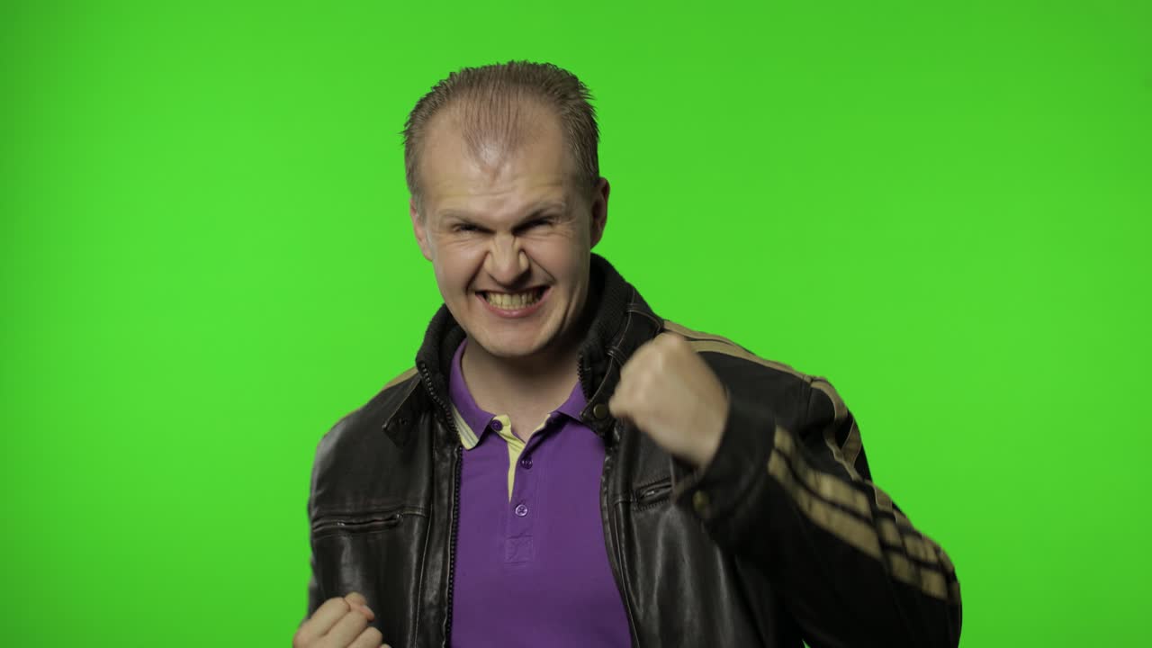 loco rocker desbordado hombre en la llave de croma levantando los puños gesticulando sí éxito, celebrando el triunfo