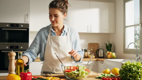woman preparing a fresh salad in a bright kitchen