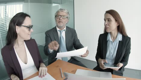 bearded middle-aged ceo reading statistics and showing report