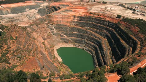 drone shot revealing an abandoned mine pit and a mining site in the background in western australia