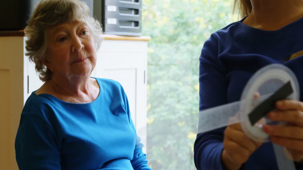 고령 여성의 무 ⁇ 을 검사하는 물리치료사 4k