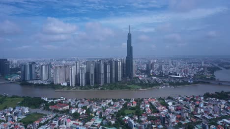 Vuelo-Aéreo-En-El-Río-Saigon,-Gran-Desarrollo-Residencial-Moderno-Y-Horizonte-De-La-Ciudad-En-Un-Día-Claro-Y-Soleado-En-La-Ciudad-De-Ho-Chi-Minh,-Vietnam